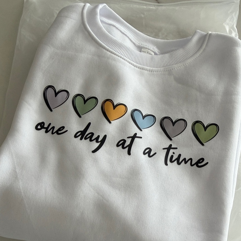 White Crewneck Sweatshirt with Multicolor Heart Graphic - One Day at a Time